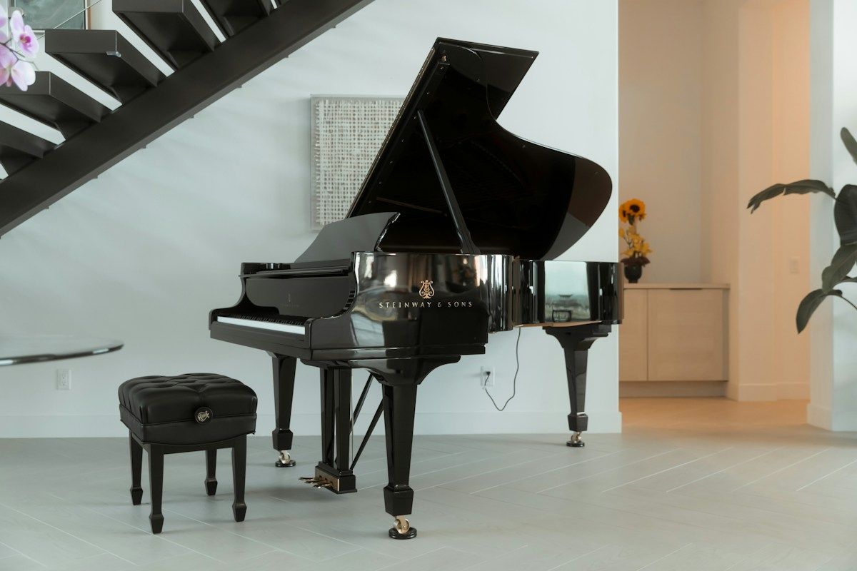 Grand piano in a living room beside a staircase